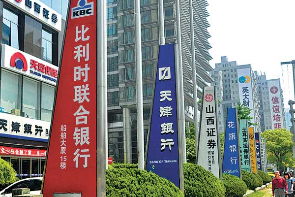 Banners and advertisements of Chinese and foreign financial institutions in Shanghai. The planned pilot free trade zone in the city is attracting major foreign banks to set up branches there for a wider range of yuan businesses