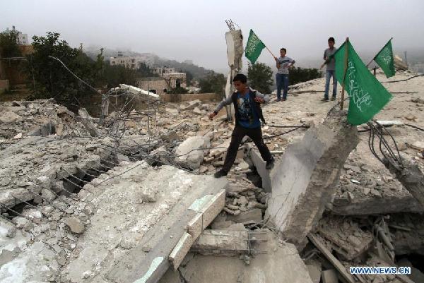Palestinian boys stand on the rubble of the house of Hussam Kawasme, a Palestinian who Israel suspects of the abduction and killing of three Israeli teenagers in June, after it was demolished by Israeli troops in the West Bank City of Hebron on Aug. 18, 2014. Israeli troops on Monday demolished the homes of two Palestinians it suspects of the abduction and killing of three teenagers in the occupied West Bank in June, the army said. 