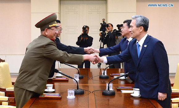 Hwang Pyong So (front, L), director of the General Political Bureau of the Korean People's Army of the Democratic People's Republic of Korea (DPRK), and Kim Kwan-jin (front R), chief of the National Security Office of South Korea, shake hands prior to their meeting in the truce village of Panmunjom, Aug. 22, 2015. [Photo/Xinhua]